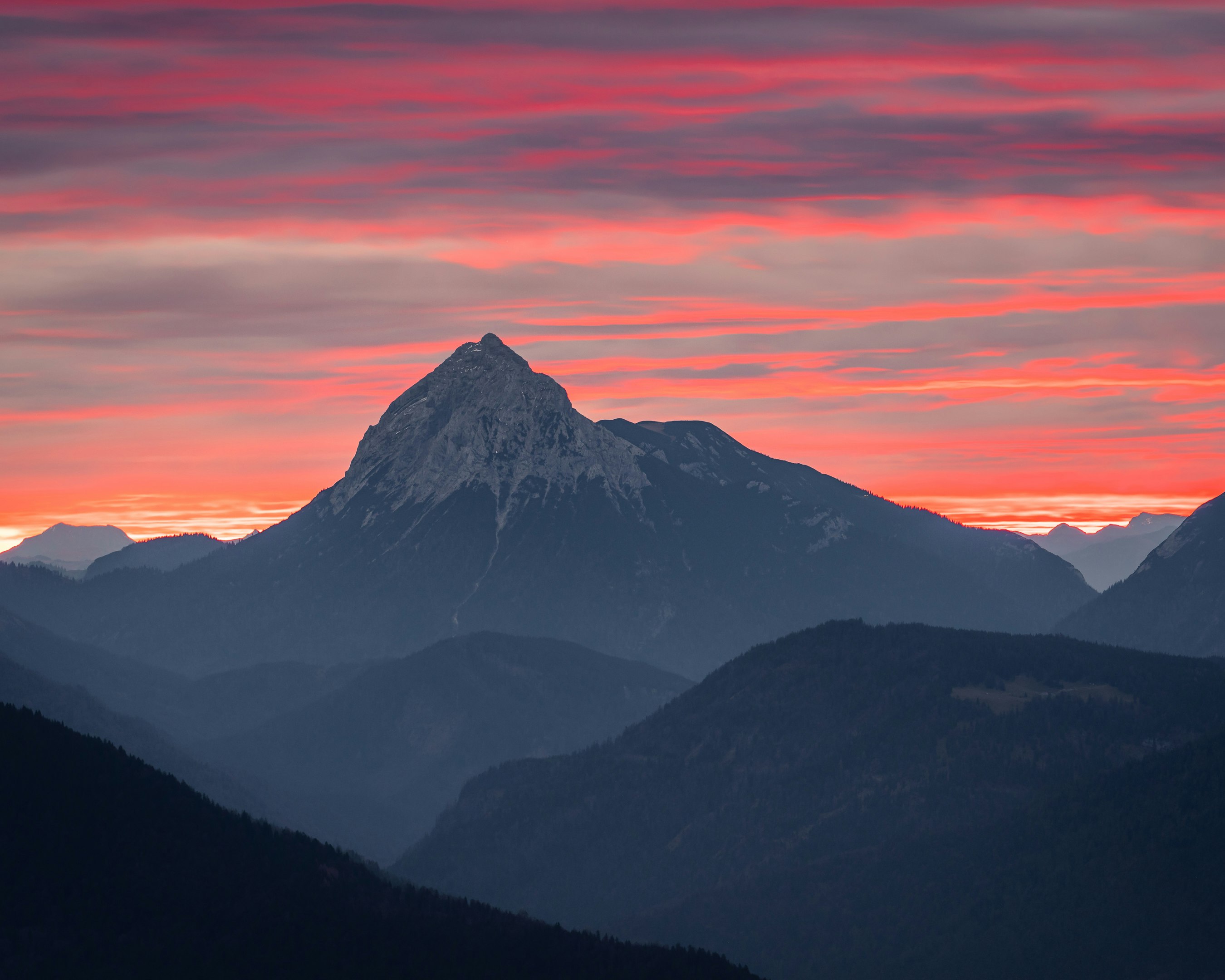 black and white mountains under orange sky